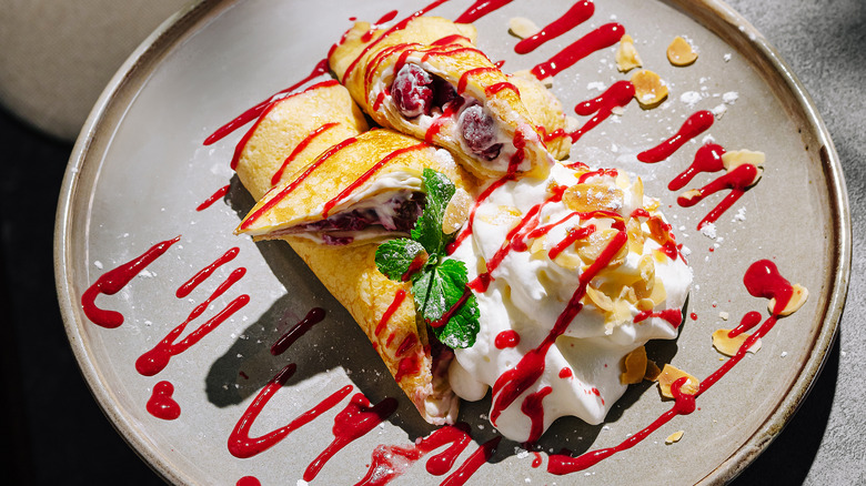 crêpes with fruit and whipped cream on a plate