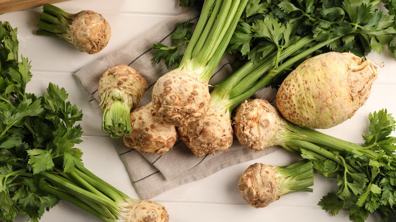 fresh celery roots on white wooden table