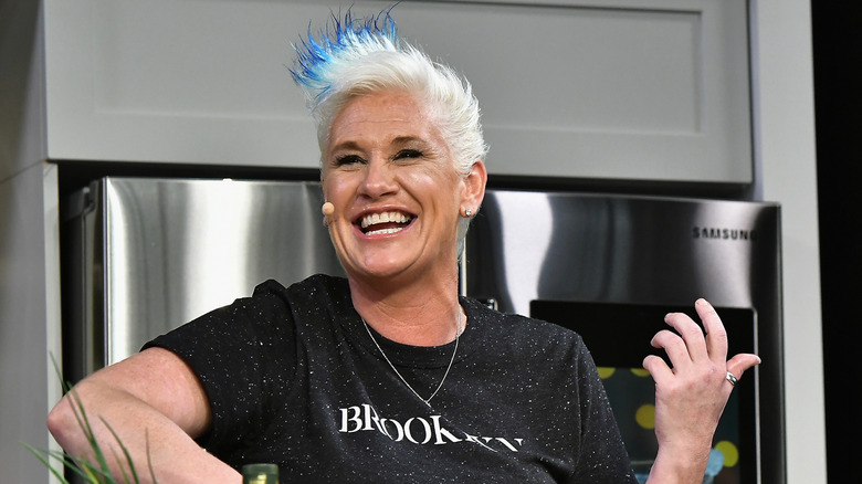 Chef Anne Burrell smiling and cooking on stage