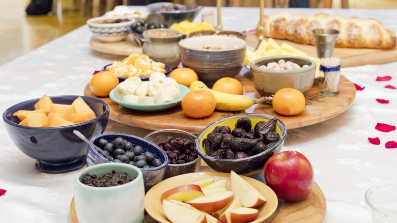 A table is set with three lazy Susans holding various plated fruits
