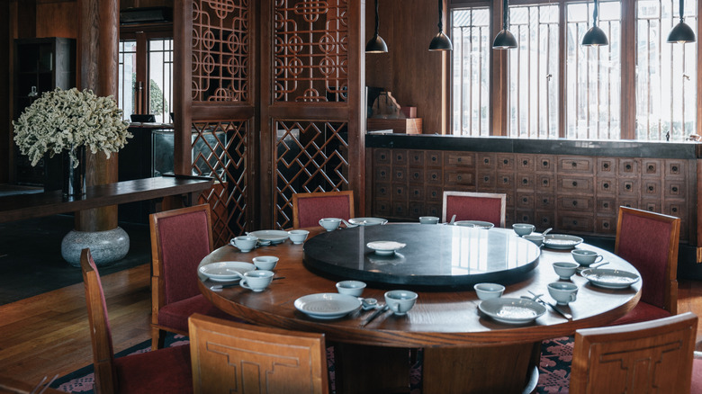 The interior of a Chinese restaurant, featuring a round table with a lazy Susan on top