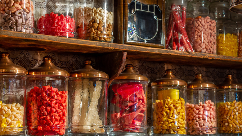 Jars full of candy lined up on two shelves