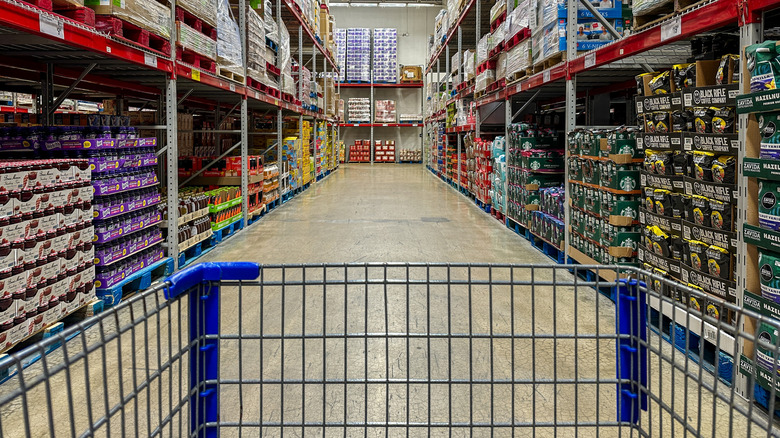 A cart in a bulk grocery store aisle.