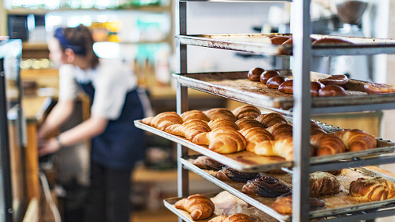 Several trays of fresh baked goods in a large commercial kitchen