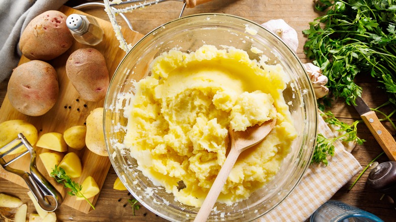 overhead shot of bowl of mashed potatoes with ingredients used bordering it