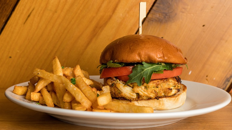 crab cake on a bun with lettuce and sliced tomato