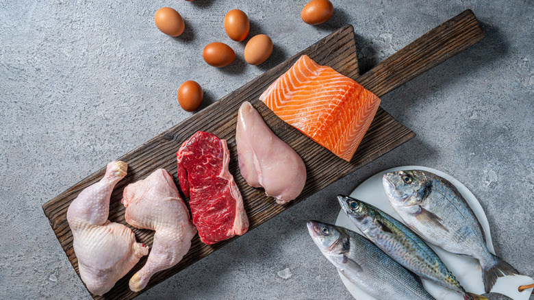 Chicken, steak, fish, and eggs plated on a cutting board