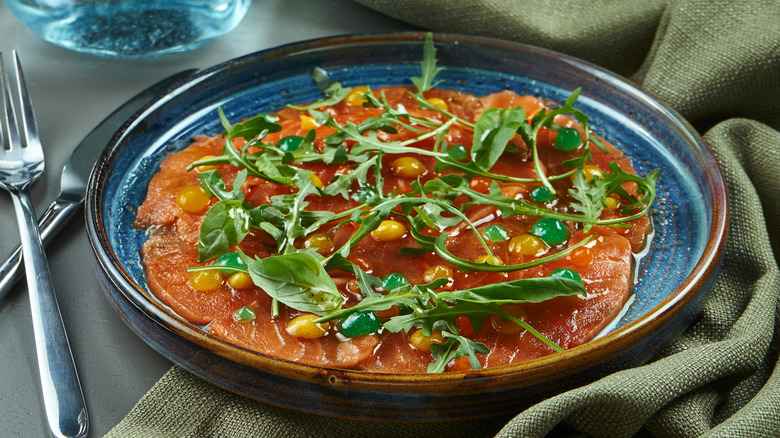 Salmon crudo with arugula and sauces