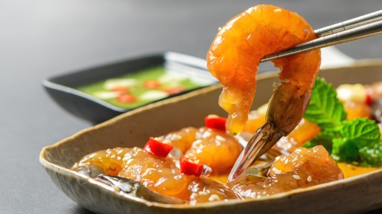 Pickled shrimp being picked up with chopsticks
