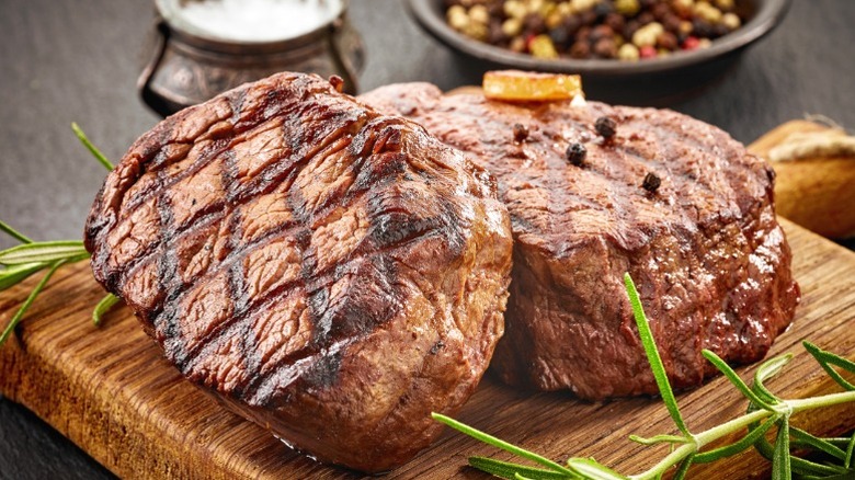 Two thick steaks on a wooden cutting board