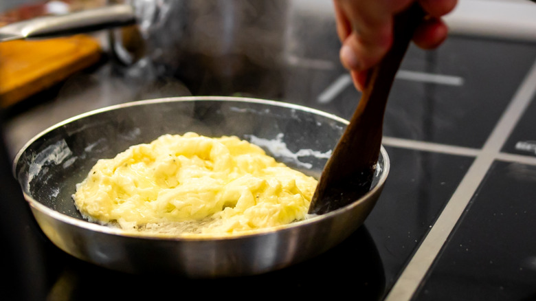 Person scrambling eggs in a pan
