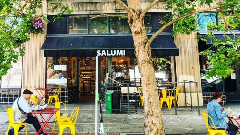 Patrons eat outside Salumi deli in Seattle