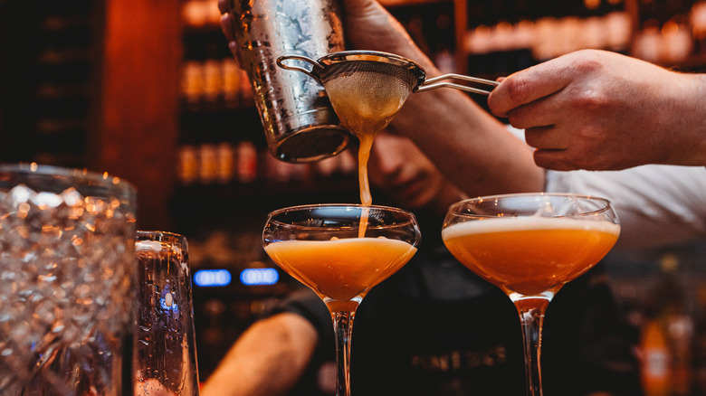 Bartender using strainer for cocktail
