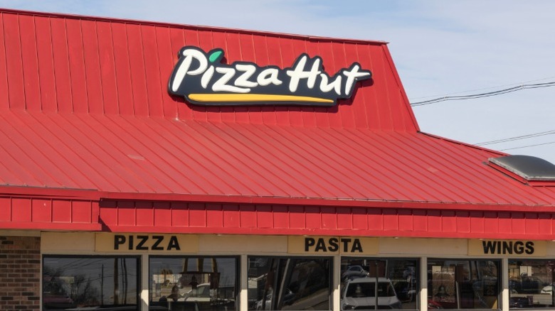 The exterior of a Pizza Hut restaurant with its trademark red roof.