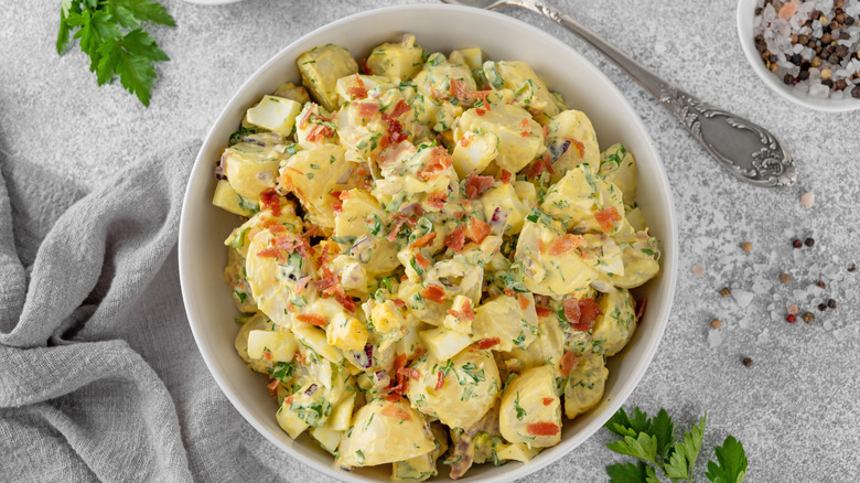A bowl of creamy potato salad with fresh herbs
