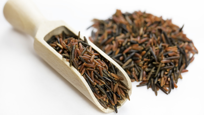A wooden scooper with a heaping of wild rice
