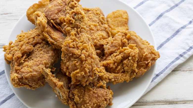 Plate of fried chicken on a white and blue striped towel
