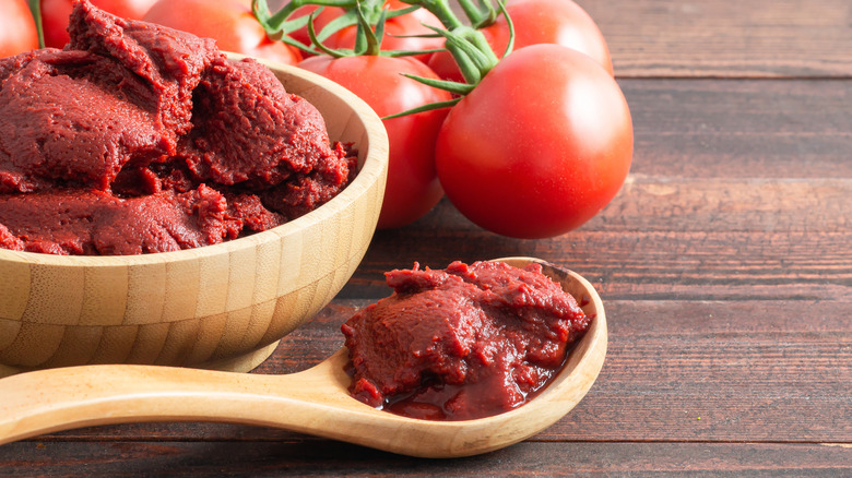 tomato paste in a wooden bowl and spoon