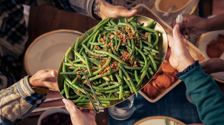A family holds up a plate of green beans