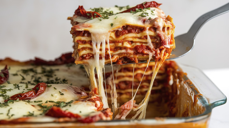 Slice of lasagna being lifted from baking dish