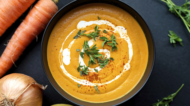 Creamy carrot soup in black bowl