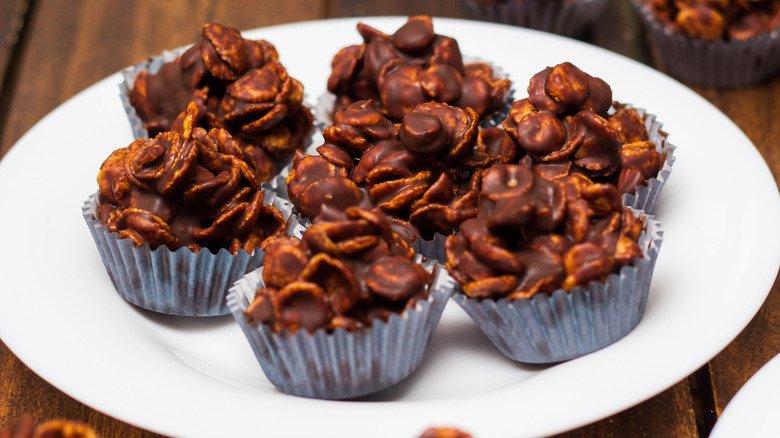 Chocolate-covered corn flakes in silver muffin cups on a plate