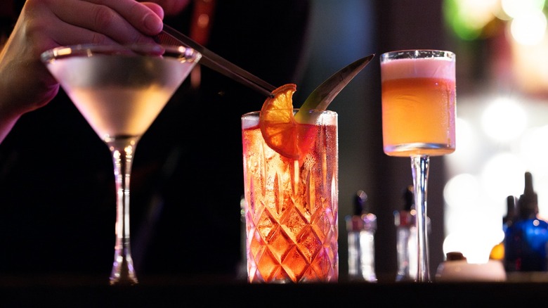 hand garnishing a cocktail