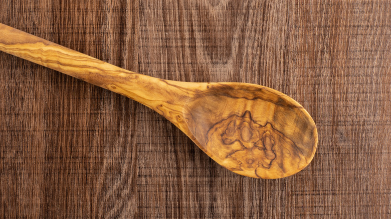 Olivewood wooden spoon against wooden background