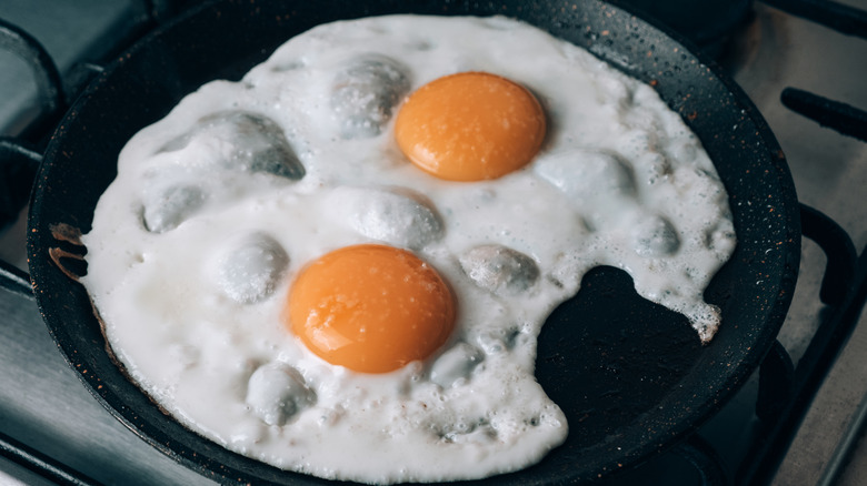 Eggs frying in a cast iron pan