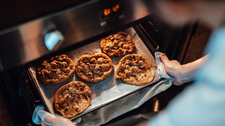 person pulling cookies out of oven
