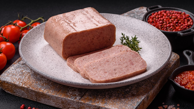 Sliced Spam on a plate with tomatoes and spices