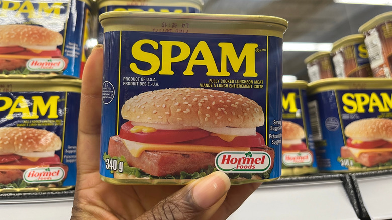 A shopper holds a can of Spam at a grocery store
