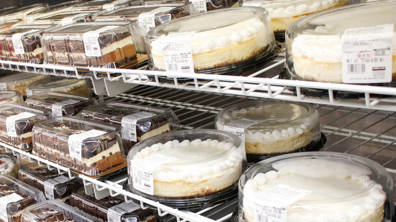 Costco plain cheesecakes and Tuxedo cake on refrigerator shelves
