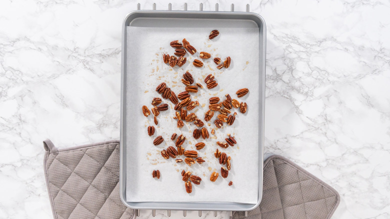 Toasted pecans on parchment-lined baking sheet