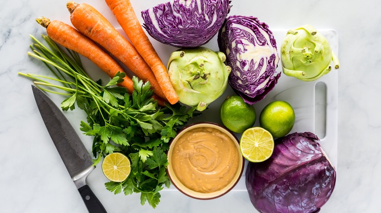 raw ingredients for coleslaw including cabbage carrots kohlrabi