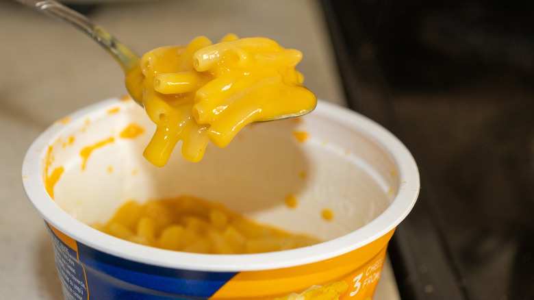 A spoon holding up a spoonful of Kraft Easy Mac microwaved macaroni and cheese