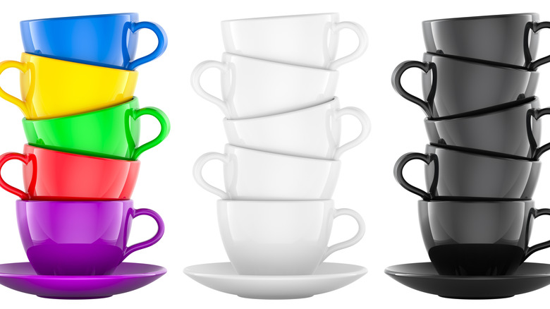 Three stacks of colored and monochrome coffee mugs