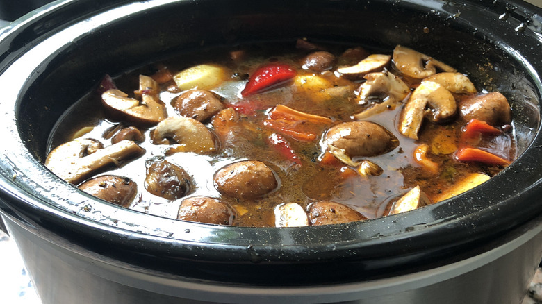 A slow cooker filled with meat and vegetables.