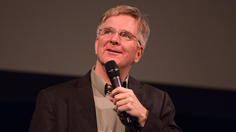 Rick Steves holding microphone and looking up