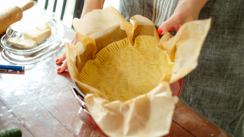 Woman holding a pie crust in a tin