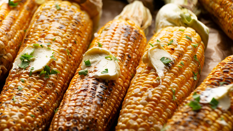 Pieces of butter melting on ears of corn