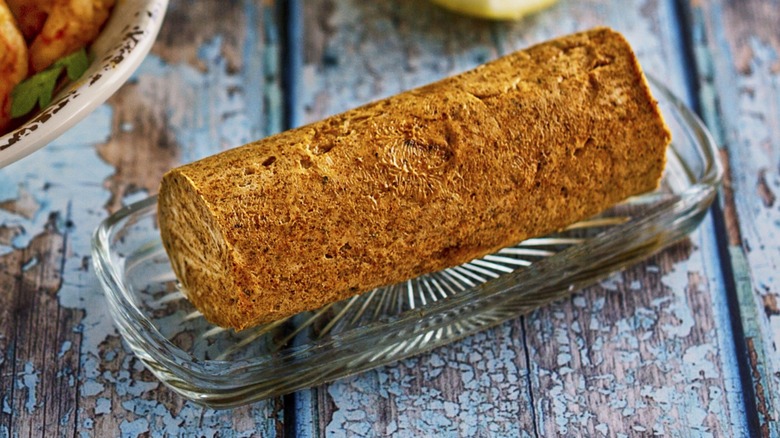 A seasoned compound butter log served on a picnic table