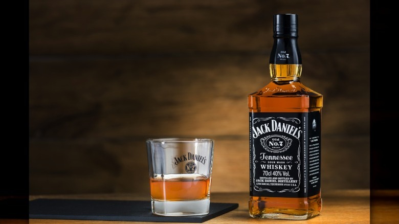 Bottle of jack daniel's whiskey next to rocks glass