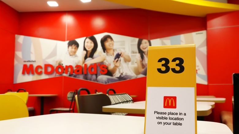 Interior of McDonald's with order number sign on table