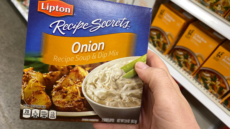 Holding a box of onion soup mix in a grocery store aisle