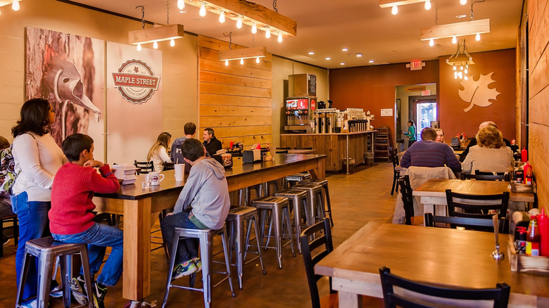 An interior shot of a Maple Street Biscuit Company, with some families and some empty tables
