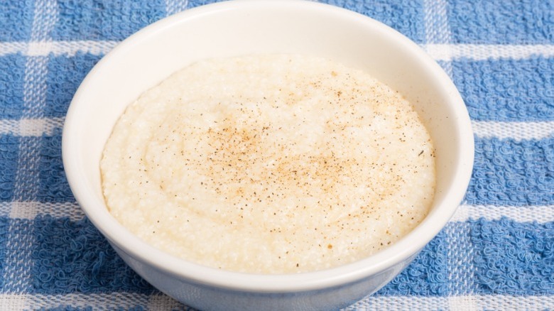 A bowl of grits on a blue and white checkered tablecloth.