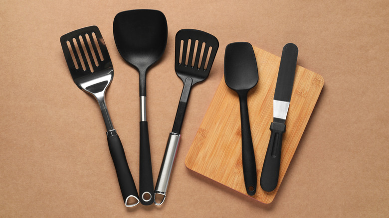 An array of different spatulas against a light brown background