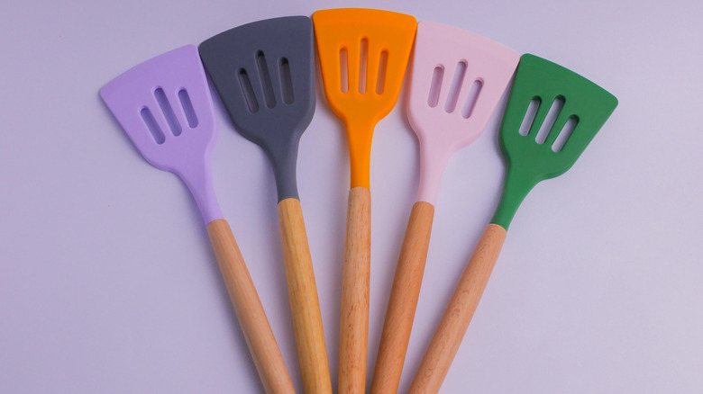 Five colored silicone spatulas arranged in a fan pattern