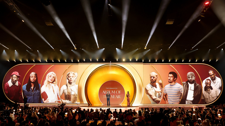 Two people standing on the stage at 2026 Grammy Awards with audience below